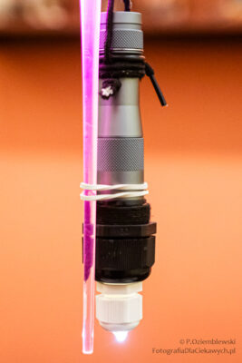 Latarka z końcówką w postaci kryształka oraz doczepiona do niej gumką dodatkowy podświetlony pręt z pleksi.