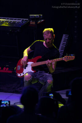 Wzrok gitarzysty skierowany na dłoń na gryfie gitary.